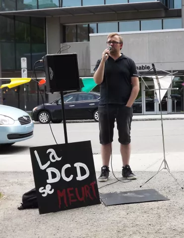Vania Wright-Larin, coordonnateur du Regroupement d&rsquo;&eacute;ducation populaire en action communautaire des r&eacute;gions de Qu&eacute;bec et Chaudi&egrave;re-Appalaches (R&Eacute;PAC), au rassemblement du 1er juin pour un meilleur financement de la d&eacute;fense collective des droits